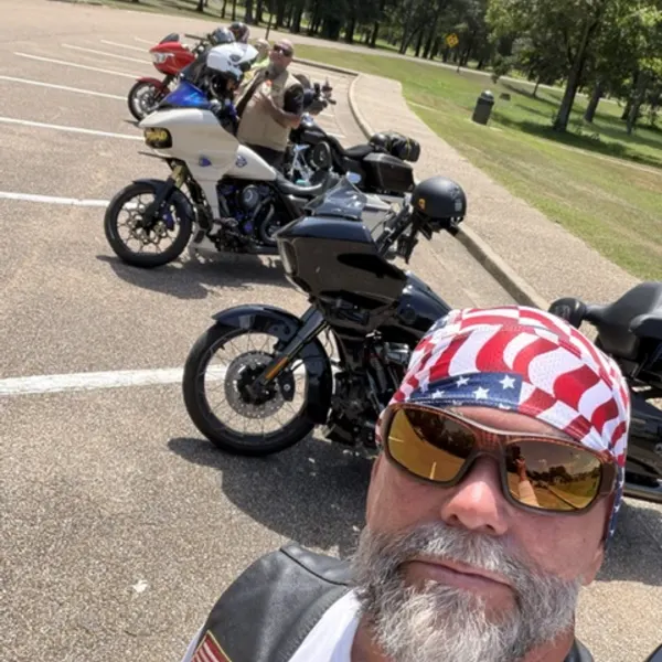 Motorcycles parked in a line at a roadside rest area.